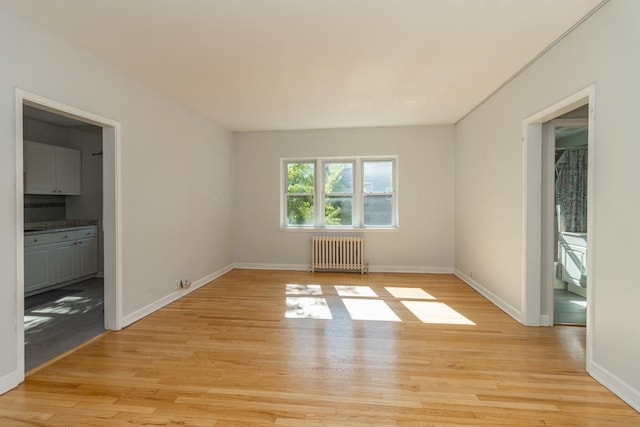 3128 Bde Maka Ska Blvd Unit 415, Minneapolis, MN 55416 - unfurnished room with radiator heating unit, light wood finished floors, and baseboards