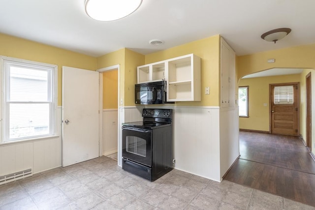509 8th Ave SE, Waseca, MN 56093 - kitchen featuring black appliances, arched walkways, wainscoting, a baseboard heating unit, and open shelves