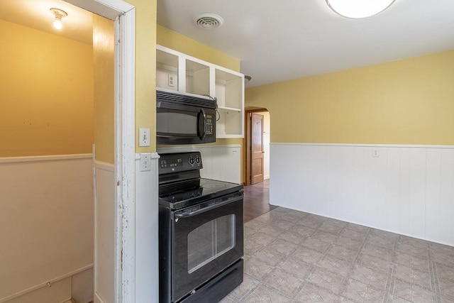 509 8th Ave SE, Waseca, MN 56093 - kitchen featuring black appliances, a wainscoted wall, arched walkways, and open shelves