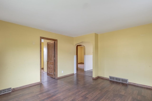 509 8th Ave SE, Waseca, MN 56093 - unfurnished room with arched walkways, dark wood-style floors, and baseboards