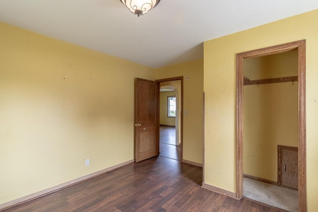 509 8th Ave SE, Waseca, MN 56093 - unfurnished bedroom featuring dark wood-style floors, a closet, and baseboards