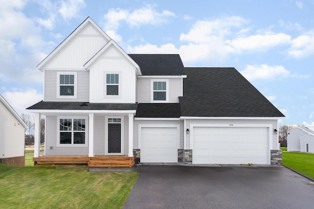 4818 163rd St N, Hugo, MN 55038 - view of front of house with driveway, stone siding, board and batten siding, and a shingled roof