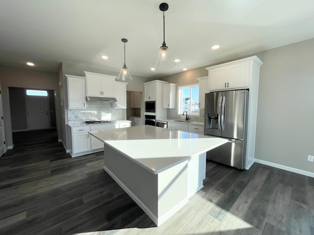 4818 163rd St N, Hugo, MN 55038 - kitchen featuring stainless steel appliances, a sink, a kitchen island, tasteful backsplash, and white cabinets