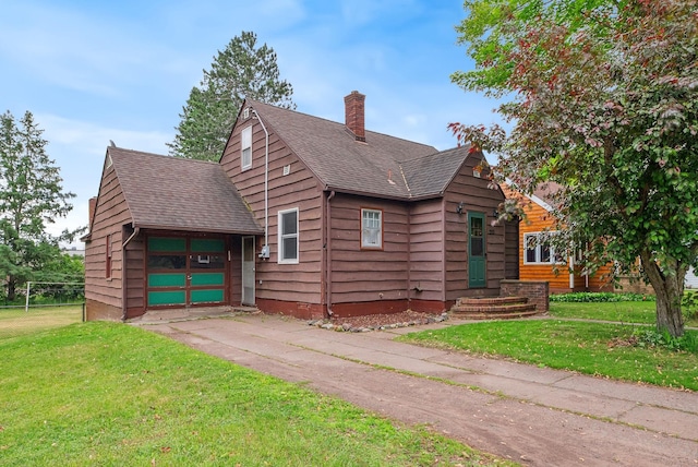 517 Birch Ave, Moose Lake, MN 55767 - view of front of property featuring a chimney, driveway, roof with shingles, and a garage