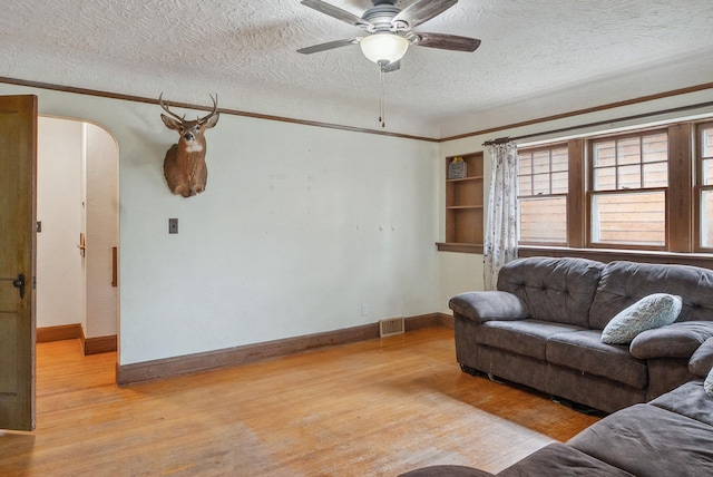 517 Birch Ave, Moose Lake, MN 55767 - living room with wood finished floors, a textured ceiling, arched walkways, and baseboards