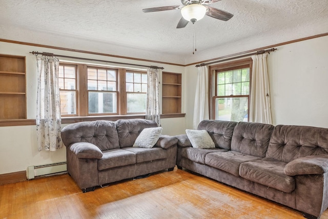 517 Birch Ave, Moose Lake, MN 55767 - living area with a baseboard radiator, a ceiling fan, light wood-style floors, a textured ceiling, and built in shelves