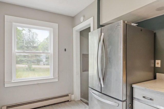517 Birch Ave, Moose Lake, MN 55767 - kitchen featuring freestanding refrigerator, a baseboard heating unit, light stone counters, and white cabinetry