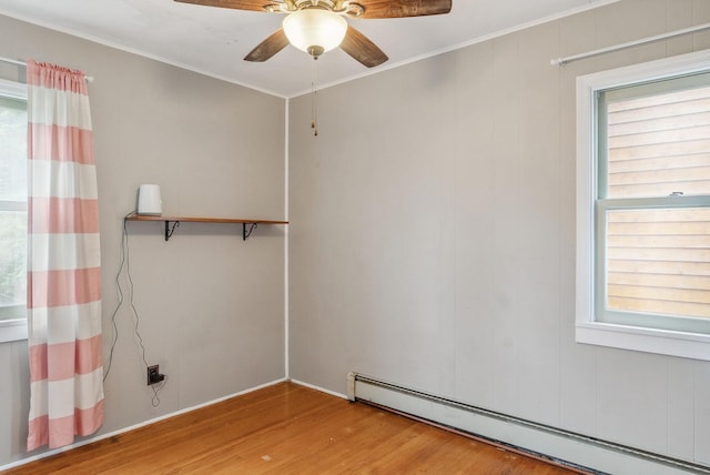 517 Birch Ave, Moose Lake, MN 55767 - empty room with a baseboard radiator, wood finished floors, ornamental molding, a ceiling fan, and plenty of natural light