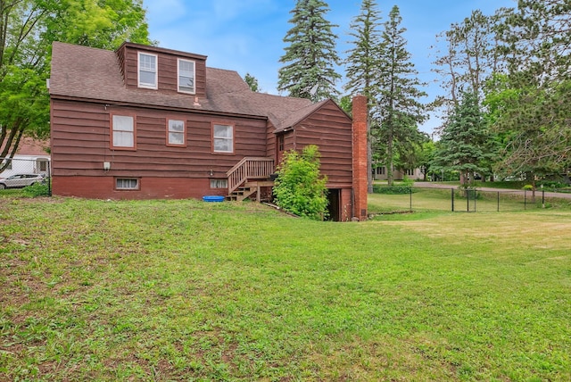 517 Birch Ave, Moose Lake, MN 55767 - back of house with a shingled roof, stairway, and a chimney