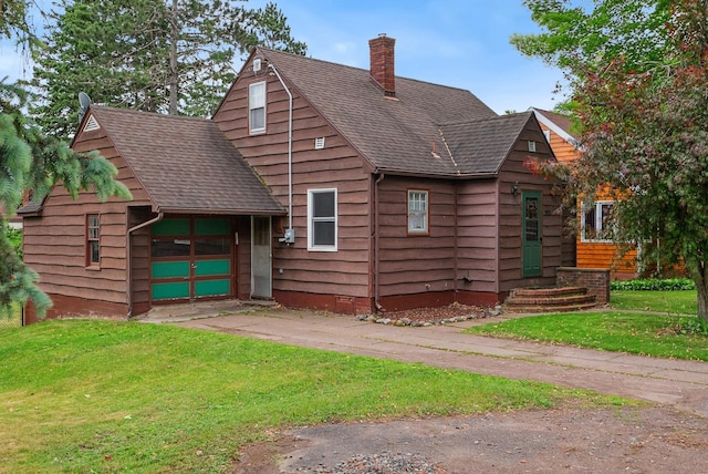 517 Birch Ave, Moose Lake, MN 55767 - view of front facade featuring a chimney, a front lawn, roof with shingles, driveway, and a garage