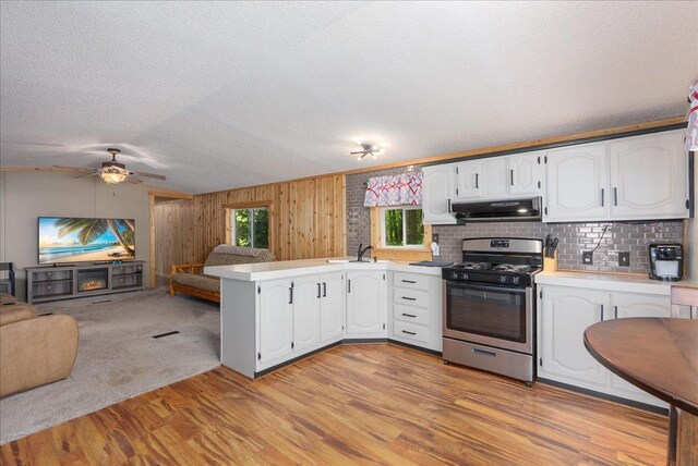 134315 Lone Pine Ln, Garfield Twp, WI 54001 - kitchen featuring stainless steel gas stove, open floor plan, a sink, a peninsula, and under cabinet range hood