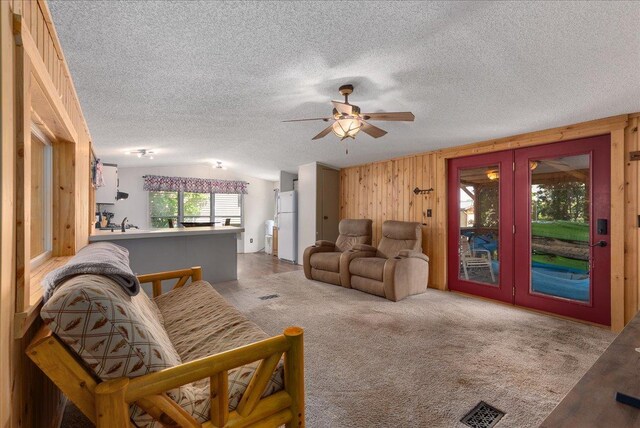 134315 Lone Pine Ln, Garfield Twp, WI 54001 - living room with vaulted ceiling, french doors, wooden walls, a ceiling fan, and a textured ceiling