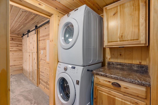 134315 Lone Pine Ln, Garfield Twp, WI 54001 - laundry room with stacked washer / drying machine, wood walls, cabinet space, a barn door, and carpet floors