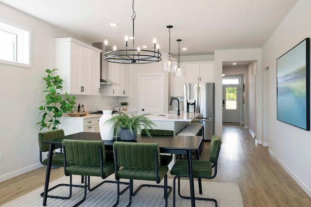 12443 Drayton Trl, Apple Valley, MN 55124 - kitchen with stainless steel refrigerator with ice dispenser, a chandelier, an island with sink, a sink, and light wood finished floors