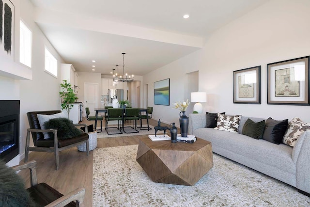 12443 Drayton Trl, Apple Valley, MN 55124 - living room with light wood-type flooring, a chandelier, recessed lighting, and a glass covered fireplace
