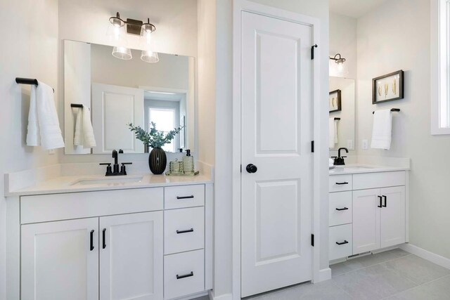 12443 Drayton Trl, Apple Valley, MN 55124 - bathroom featuring two vanities, baseboards, and tile patterned flooring