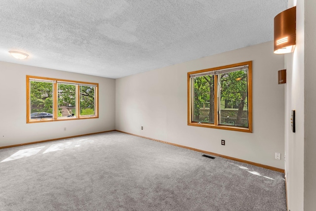 1809 Penn Ave N, Minneapolis, MN 55411 - unfurnished room featuring plenty of natural light, carpet, baseboards, a textured ceiling, and a wall mounted air conditioner