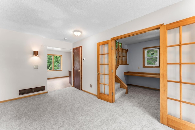1809 Penn Ave N, Minneapolis, MN 55411 - carpeted spare room featuring french doors, a textured ceiling, and baseboards