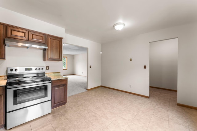 1809 Penn Ave N, Minneapolis, MN 55411 - kitchen with stainless steel electric range oven, under cabinet range hood, baseboards, and light stone counters