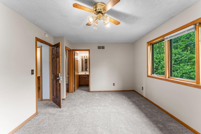 1809 Penn Ave N, Minneapolis, MN 55411 - unfurnished bedroom featuring baseboards, light colored carpet, a textured ceiling, ensuite bathroom, and ceiling fan