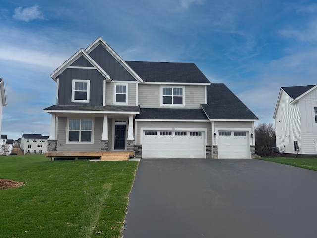 16290 Fairoaks Ave N, Hugo, MN 55038 - craftsman house featuring stone siding, board and batten siding, asphalt driveway, a front yard, and covered porch