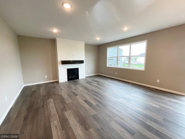 16290 Fairoaks Ave N, Hugo, MN 55038 - unfurnished living room featuring dark wood-style flooring, a fireplace, and recessed lighting