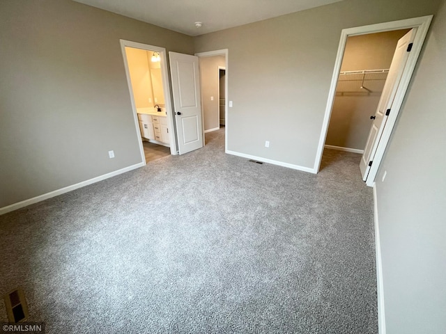 16290 Fairoaks Ave N, Hugo, MN 55038 - unfurnished bedroom featuring a walk in closet, carpet floors, a closet, and ensuite bath