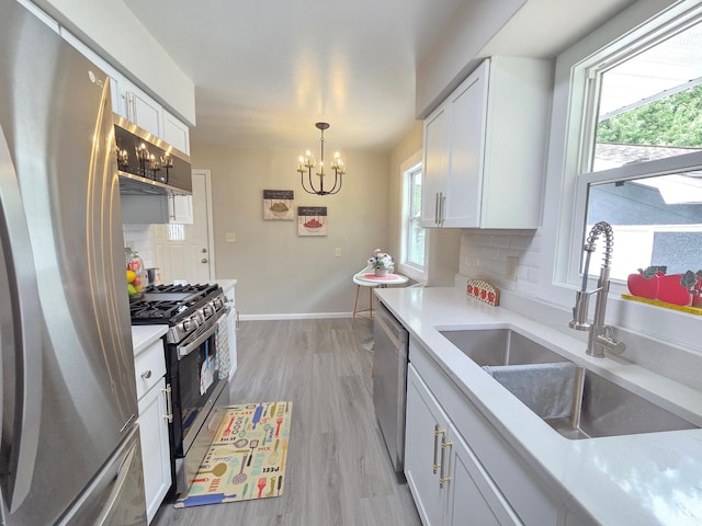 4106 Woodbine Ln N, Brooklyn Center, MN 55429 - kitchen with stainless steel appliances, a sink, decorative backsplash, a chandelier, and white cabinets
