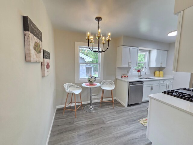 4106 Woodbine Ln N, Brooklyn Center, MN 55429 - kitchen featuring dishwasher, a sink, a chandelier, cooktop, and light wood-type flooring