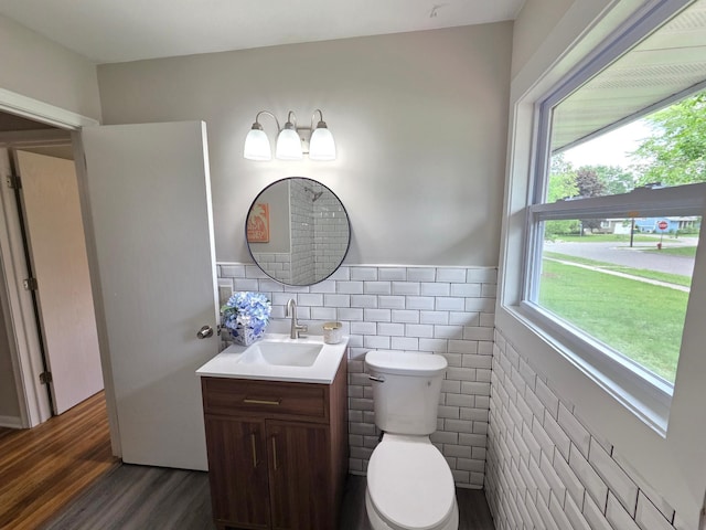 4106 Woodbine Ln N, Brooklyn Center, MN 55429 - half bath with vanity, wood finished floors, toilet, tile walls, and wainscoting
