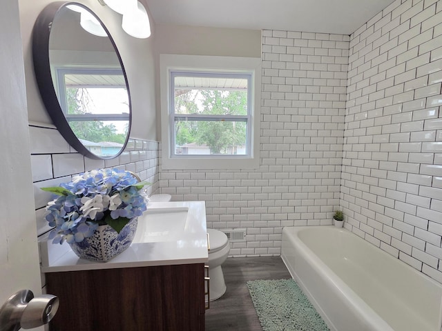 4106 Woodbine Ln N, Brooklyn Center, MN 55429 - full bath with tile walls, vanity, toilet, and wood finished floors
