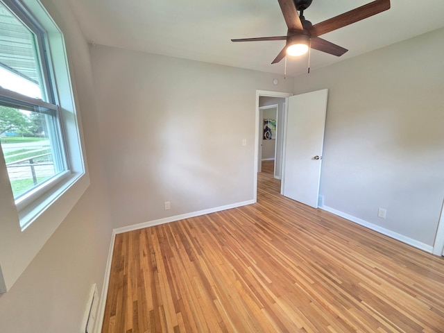 4106 Woodbine Ln N, Brooklyn Center, MN 55429 - spare room featuring ceiling fan, baseboards, light wood-type flooring, and baseboard heating