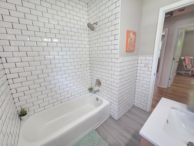 4106 Woodbine Ln N, Brooklyn Center, MN 55429 - full bathroom with tile walls, wood finished floors, bathing tub / shower combination, vanity, and a wainscoted wall