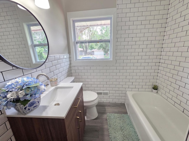 4106 Woodbine Ln N, Brooklyn Center, MN 55429 - full bath with tile walls, vanity, toilet, and wood finished floors