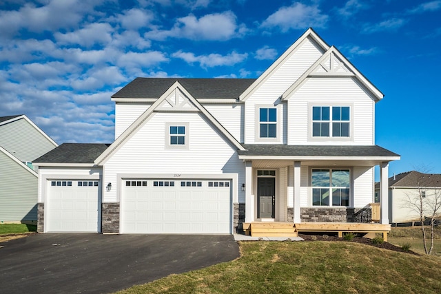 16296 Fairoaks Ave N, Hugo, MN 55038 - view of front facade with stone siding, driveway, covered porch, a front yard, and a shingled roof