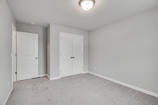 16296 Fairoaks Ave N, Hugo, MN 55038 - unfurnished bedroom with a textured ceiling, a closet, carpet flooring, and baseboards