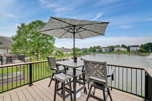 10777 181st Cir NW, Elk River, MN 55330 - deck with outdoor dining space, a water view, and a lawn