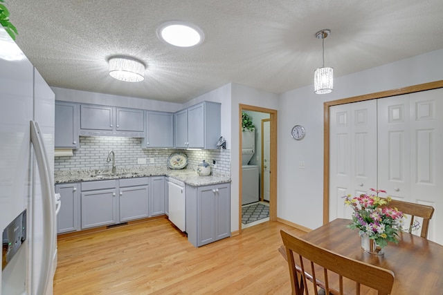 10777 181st Cir NW, Elk River, MN 55330 - kitchen featuring white appliances, backsplash, washer / clothes dryer, light wood-type flooring, and gray cabinets