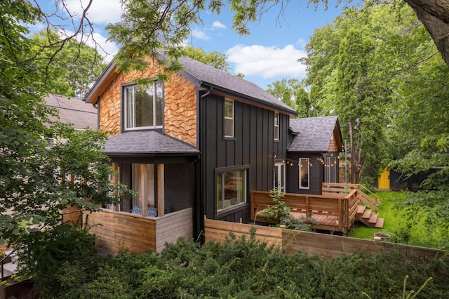 2916 26th St, Minneapolis, MN 55406 - view of front of home featuring board and batten siding, a shingled roof, and a wooden deck