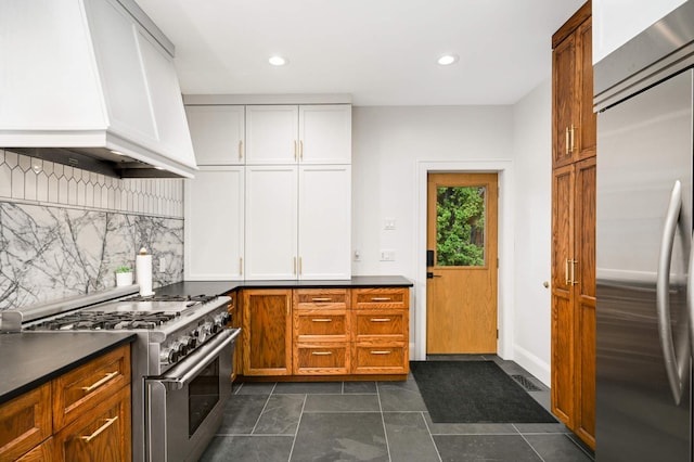 2916 26th St, Minneapolis, MN 55406 - kitchen with appliances with stainless steel finishes, custom exhaust hood, backsplash, dark countertops, and recessed lighting