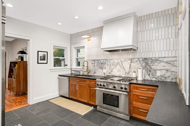 2916 26th St, Minneapolis, MN 55406 - kitchen with appliances with stainless steel finishes, a sink, dark countertops, premium range hood, and backsplash