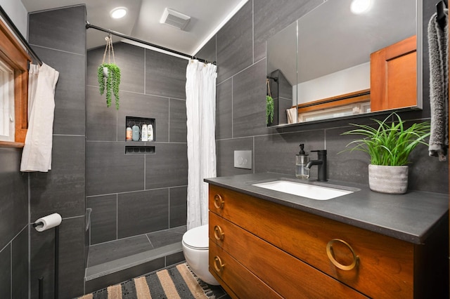 2916 26th St, Minneapolis, MN 55406 - full bathroom featuring vanity, toilet, a tile shower, backsplash, and tile walls