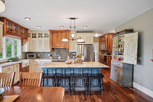 1755 Chateau Way, Minnetrista, MN 55359 - kitchen featuring stainless steel fridge with ice dispenser, a center island, dark wood-type flooring, light stone counters, and range