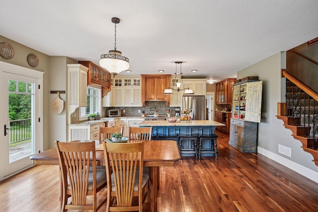 1755 Chateau Way, Minnetrista, MN 55359 - kitchen featuring stainless steel fridge with ice dispenser, glass insert cabinets, backsplash, a kitchen island, and dark wood finished floors