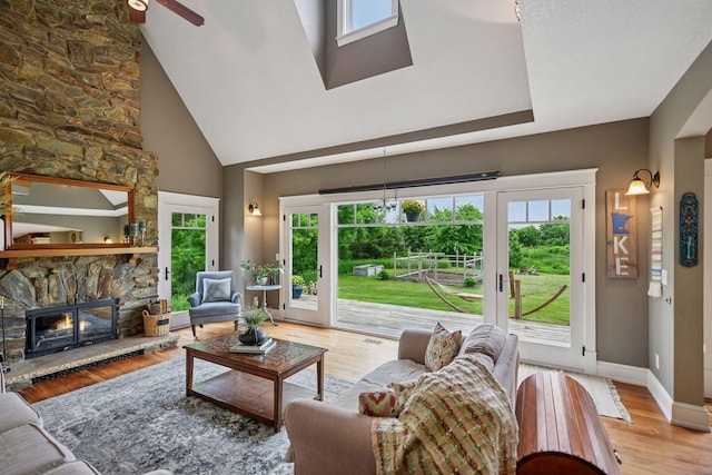 1755 Chateau Way, Minnetrista, MN 55359 - living room featuring healthy amount of natural light, a towering ceiling, ceiling fan, a fireplace, and light wood-style flooring