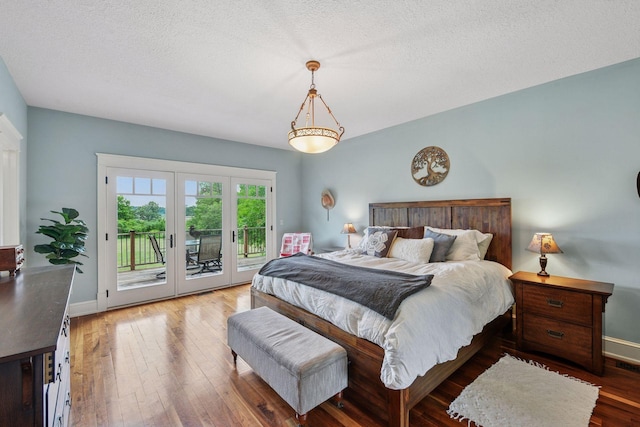 1755 Chateau Way, Minnetrista, MN 55359 - bedroom featuring access to exterior, hardwood / wood-style floors, a textured ceiling, and french doors