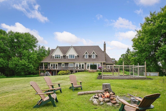 1755 Chateau Way, Minnetrista, MN 55359 - back of property with an outdoor fire pit, a wooden deck, a chimney, a lawn, and a vegetable garden