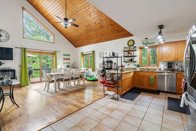 43190 Government Rd, Hinckley, MN 55037 - kitchen with appliances with stainless steel finishes, high vaulted ceiling, a ceiling fan, light tile patterned floors, and brown cabinets
