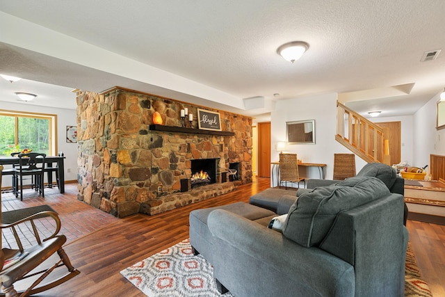 43190 Government Rd, Hinckley, MN 55037 - living area with stairway, a fireplace, a textured ceiling, and wood finished floors