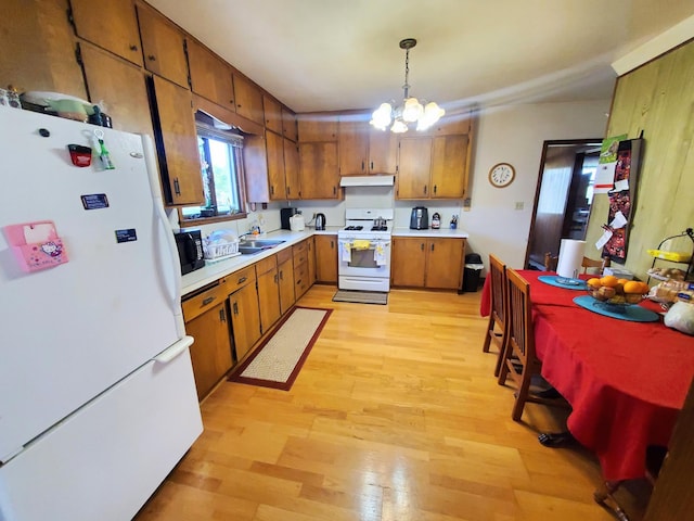 801 Greenwood Ave, Tracy, MN 56175 - kitchen with white appliances, brown cabinetry, light countertops, light wood-style flooring, and under cabinet range hood